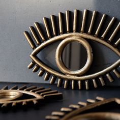 an eye shaped object is shown next to other decorative objects and mirrors on the wall