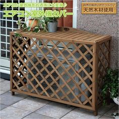 a wooden box with plants in it sitting on the side of a building next to a planter