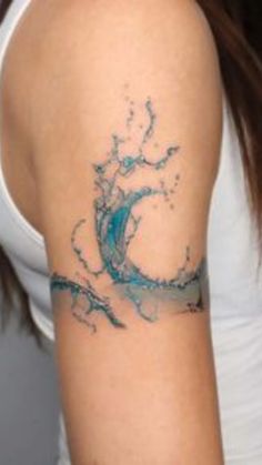 a woman's arm with a blue wave tattoo on the left side of her arm