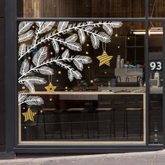 a store window with christmas decorations on the outside and gold stars in the front windows