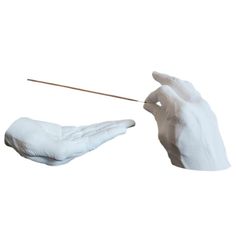 a pair of white gloves holding a stick in one hand and another hand with a wooden stick in the other