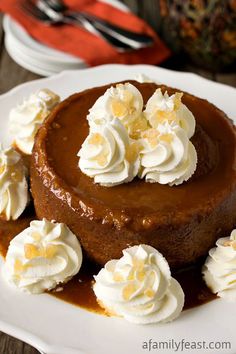 a chocolate cheesecake topped with whipped cream and caramel sauce on a white plate