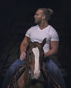 a man riding on the back of a brown and white horse