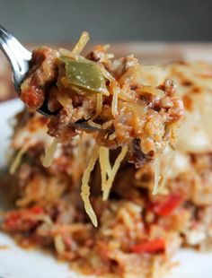 a close up of food on a plate with a fork in the foreground and a blurry background