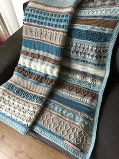 a crocheted blanket sitting on top of a couch