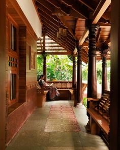 a person sitting on a bench under a wooden roof