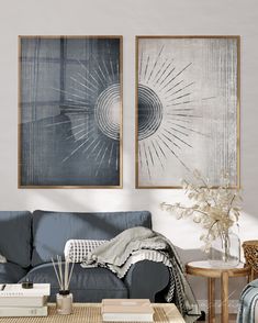 a living room with two paintings on the wall and a coffee table in front of it