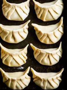 dumplings are lined up on a baking sheet ready to be cooked in the oven