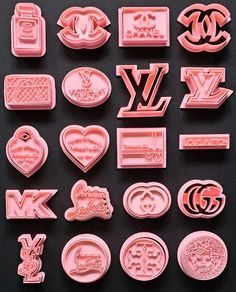 various pink plastic badges and emblems on a black surface with the letters y, l, v