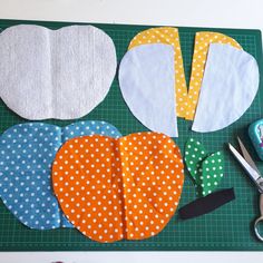 sewing supplies laid out on top of a green cutting board with scissors and fabric pieces