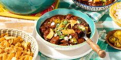 bowls of chili and tortilla chips on a table