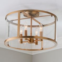 a semi - flush ceiling light fixture with clear glass shades in a living room area