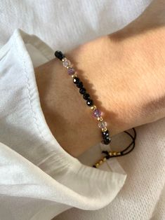 a woman's arm wearing a bracelet with beads and black onyxite stones