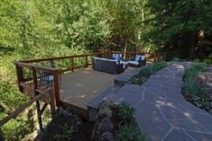 a deck in the woods with seating and trees