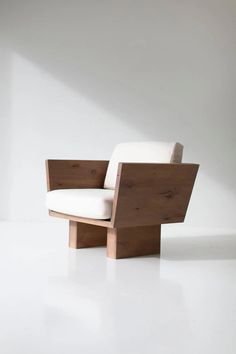 a white chair sitting on top of a white floor next to a wooden frame and seat