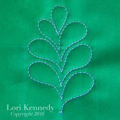 a close up of a green cloth with a stitched tree on the front and bottom