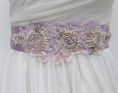 "Vintage chic bridal sash hand crafted with dip dyed Alencon lace in the prettiest shades of lavender mauve. This sash has an amazing amount of intricate detailing as many hours were spent beading the crystals, pearls & tiny seed beeds. A stunning and unique one of a kind wedding sash of heirloom quality. NOTE: On my screen the ribbon looks a bit darker than in person. READY TO SHIP DETAILS * The beaded piece measures 3\" tall (at widest part) by 12\" long. * Hand sewn onto 2\" lavender mauv Beaded Bridal Sash, Sash Wedding Dress, Floral Sash, Statement Earrings Wedding, Mauve Wedding, Wedding Dress Sash, Wedding Belt, Wedding Sash Belt, Alencon Lace