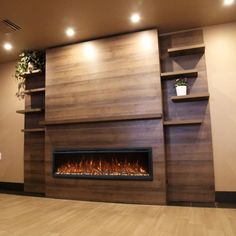 an empty room with a fireplace in the center and shelves on the wall behind it