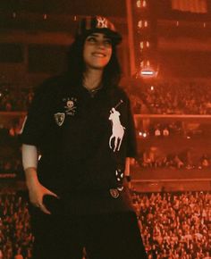 a man standing on top of a stage in front of a crowd at a concert