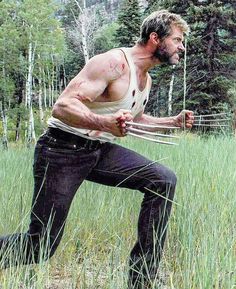 a man in the middle of a field holding a frisbee with one hand