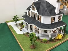 a model house is shown on a green mat