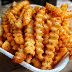 a white bowl filled with cheetos on top of a wooden table