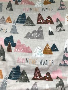 the fabric has mountains on it with words written in different colors and sizes, along with an animal