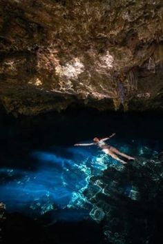 a person is swimming in the blue cave