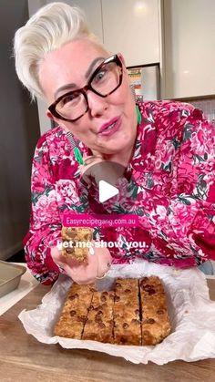 an older woman holding a tray of cookies