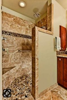 a walk in shower sitting inside of a bathroom next to a sink and counter top