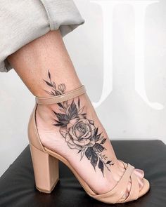 a woman's foot with a rose tattoo on it