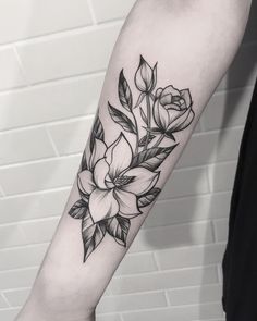 a black and white flower tattoo on the arm