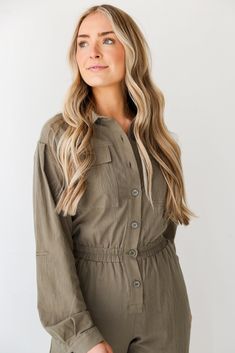 Prepare to leave everyone stunned by the way you strut in the Striking Attitude Olive Jumpsuit! This jumpsuit is designed to make a statement with its earthy olive hue, creating a look that is both effortlessly elegant and on-trend. Crafted from high-quality fabric, the olive jumpsuit offers a relaxed and comfortable fit, making it an ideal choice for various occasions. The rich olive color adds a touch of sophistication, allowing you to transition seamlessly from casual outings to more polished Fall Khaki Jumpsuits And Rompers For Work, Fall Workwear Khaki Jumpsuits And Rompers, Khaki Long Sleeve Jumpsuits And Rompers For Work, Summer Utility Button-up Jumpsuits And Rompers, Military Style Long Sleeve Cotton Jumpsuit, Utility Cotton Button-up Jumpsuits And Rompers, Olive Jumpsuit, Olive Green Jumpsuit, Khaki Military Long Sleeve Jumpsuit