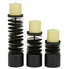 three candles sitting on top of each other in front of a white background with black bases