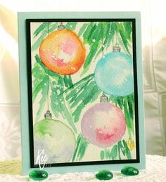 a card with watercolor christmas ornaments and palm leaves on the inside, in front of a white background