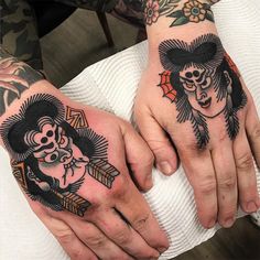 two hands with tattoos on them holding each other