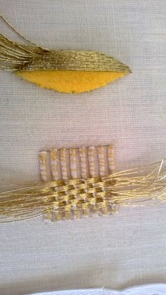 two pieces of gold colored hair sitting next to each other on a white table cloth