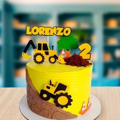 a yellow cake with construction vehicles on it