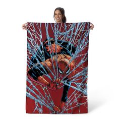 a woman holding up a spider - man poster in front of her face and hands