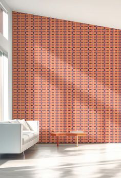 an orange and blue patterned wallpaper in a living room with a white couch next to it