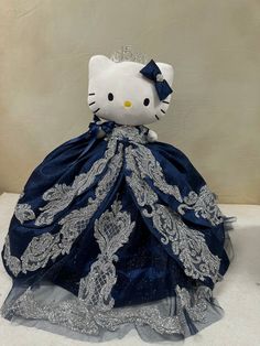 a hello kitty doll in a blue dress with silver sequins on the skirt