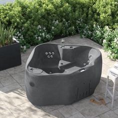 a hot tub sitting on top of a patio next to a potted planter