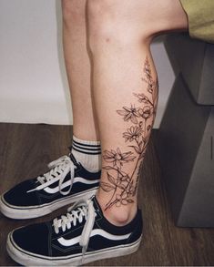 a woman's legs with flowers on them