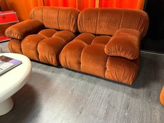 an orange couch sitting next to a white table