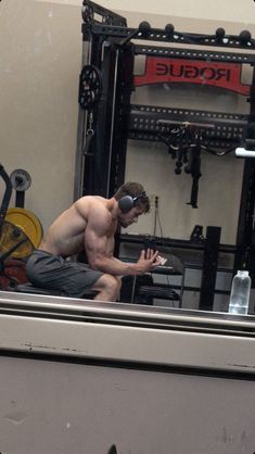 a shirtless man is sitting in the gym