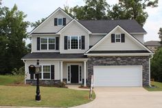 a white house with black shutters and a light post in front of the house