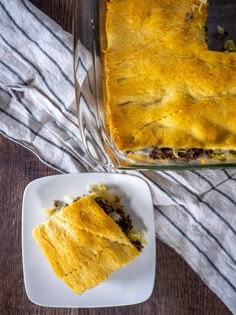 a casserole on a plate next to a glass dish filled with meat and cheese