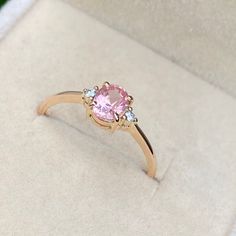 a pink diamond ring sitting in a box