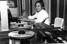 a woman sitting at a desk in front of a record player