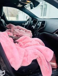 a pink blanket is in the back seat of a car